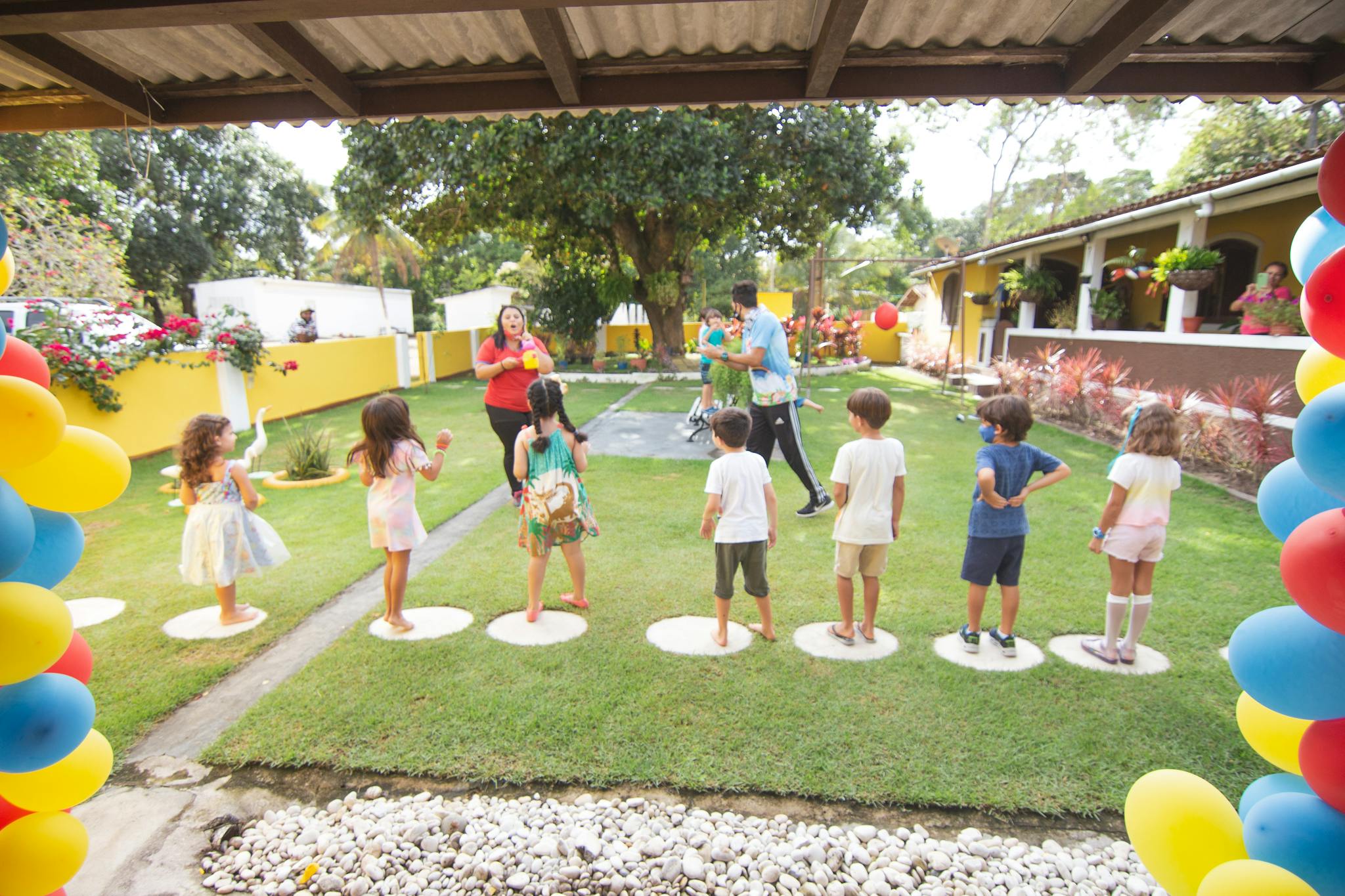 Children play at a lively outdoor birthday party with balloons and games.