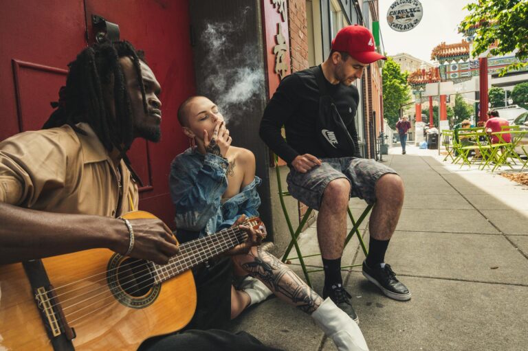 Group of musicians enjoying a jam session on a city street, showcasing urban culture and diversity.